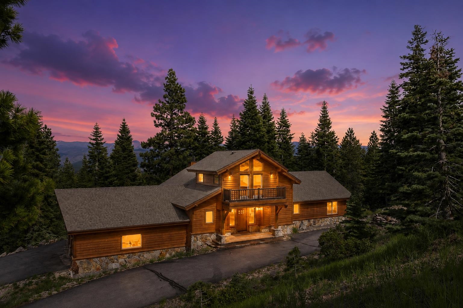 Timber house with a balcony glows among evergreens beneath a pink-purple dusk sky.
