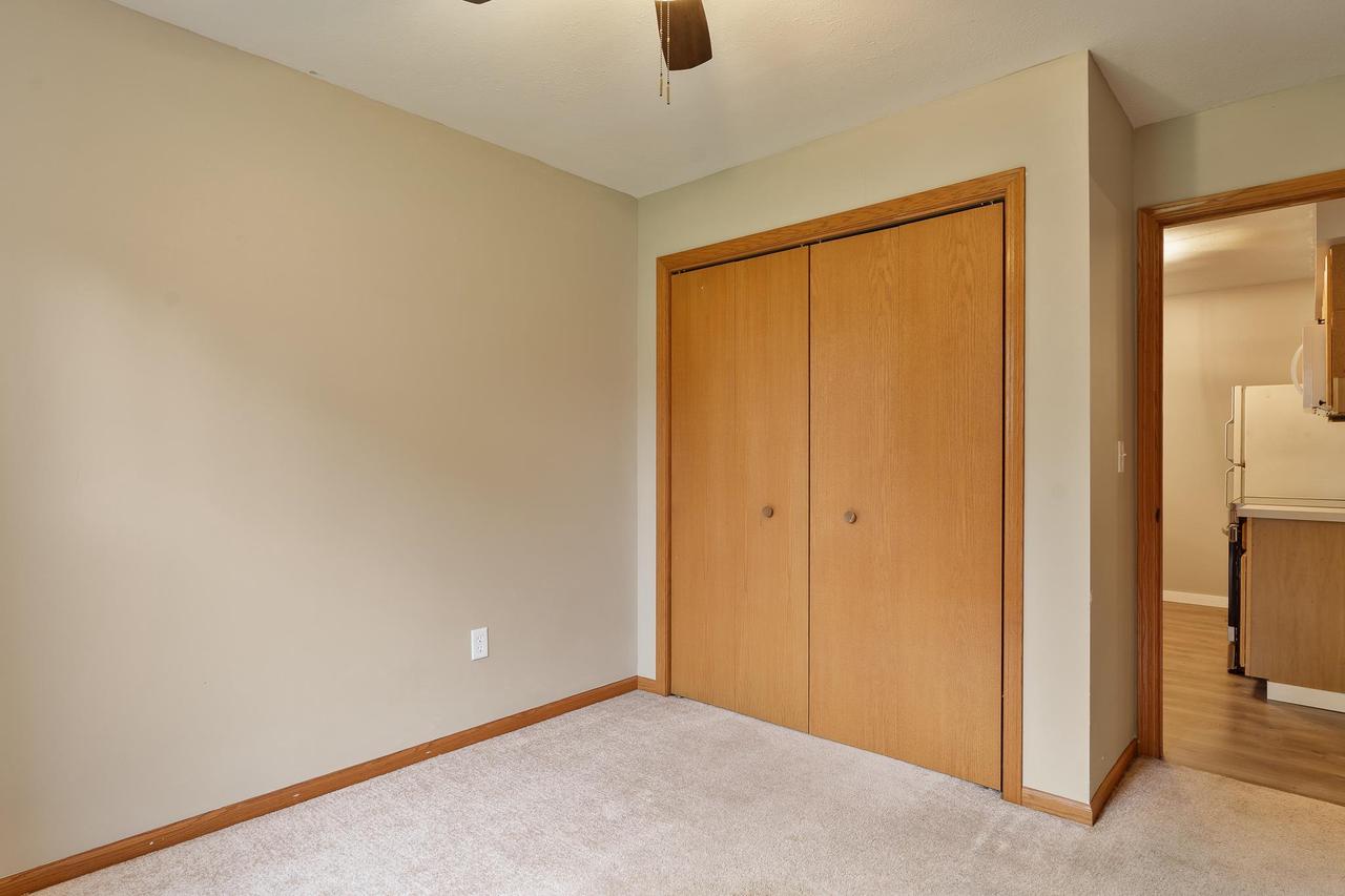 Unfurnished bedroom with sliding wood closet doors and a doorway to the kitchen.