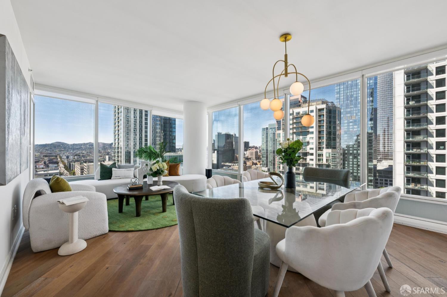 High-rise condo living and dining area with floor-to-ceiling windows overlooking the city skyline.