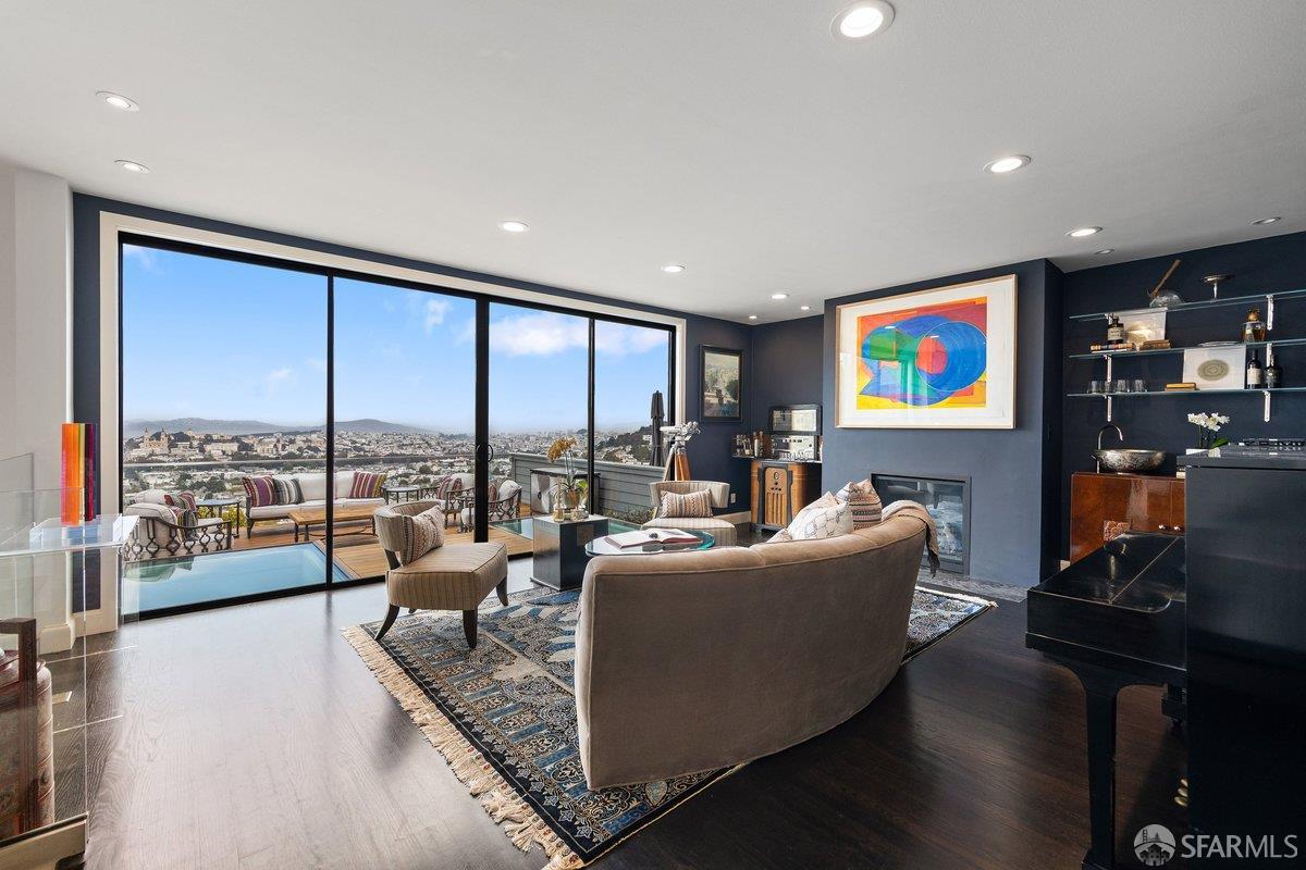 Modern living room with a curved sofa and wide windows overlooking San Francisco.