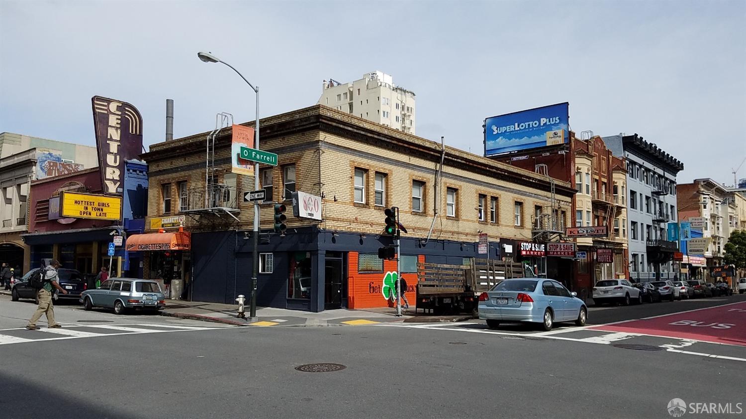 San Francisco commercial streetscape at O'Farrell Street, with corner storefronts and a theater marquee.