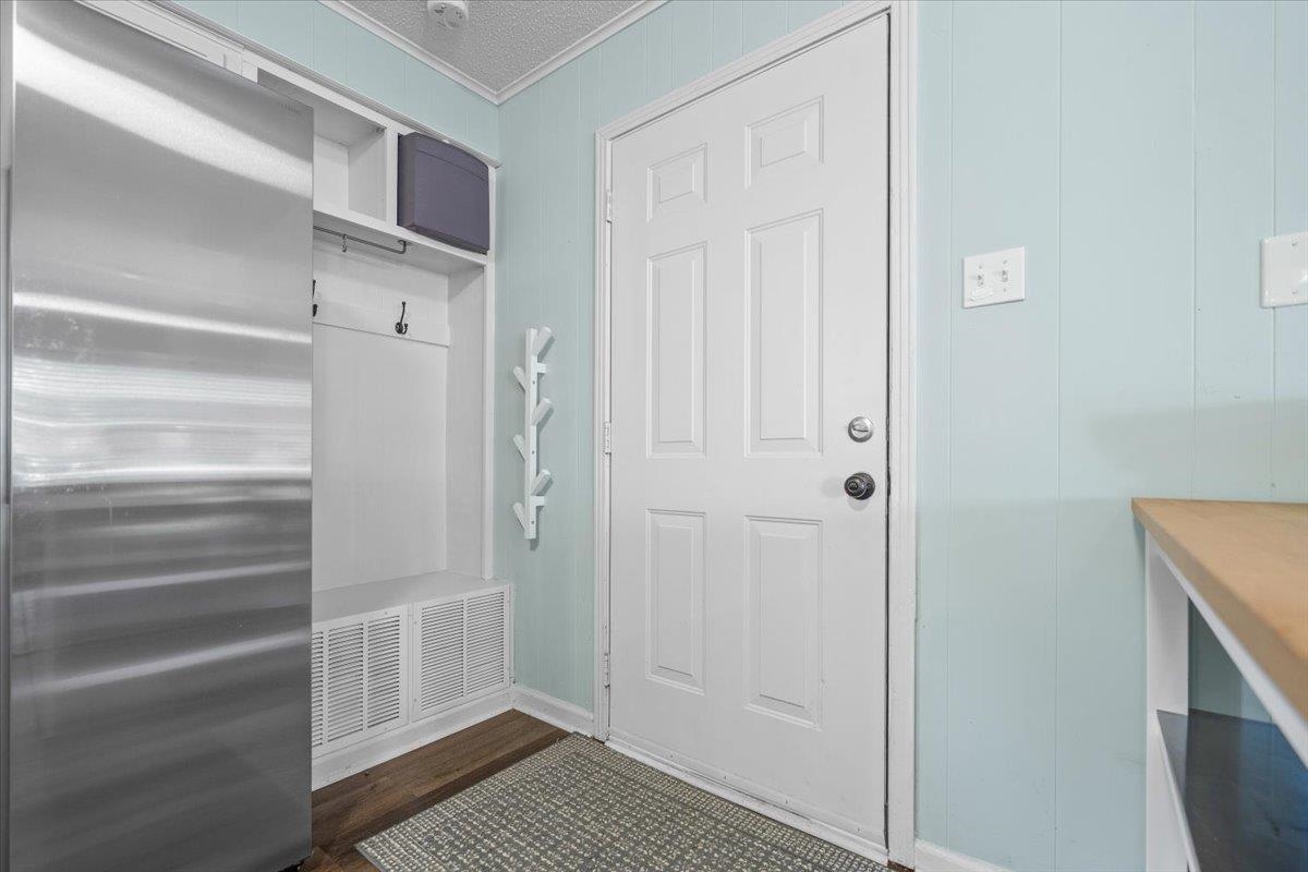Entryway with a white paneled door, built-in coat storage, and pale blue walls.