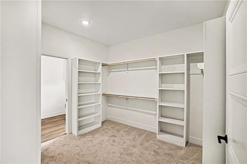 Walk-in closet with built-in shelves and double hanging rods, viewed from the doorway.