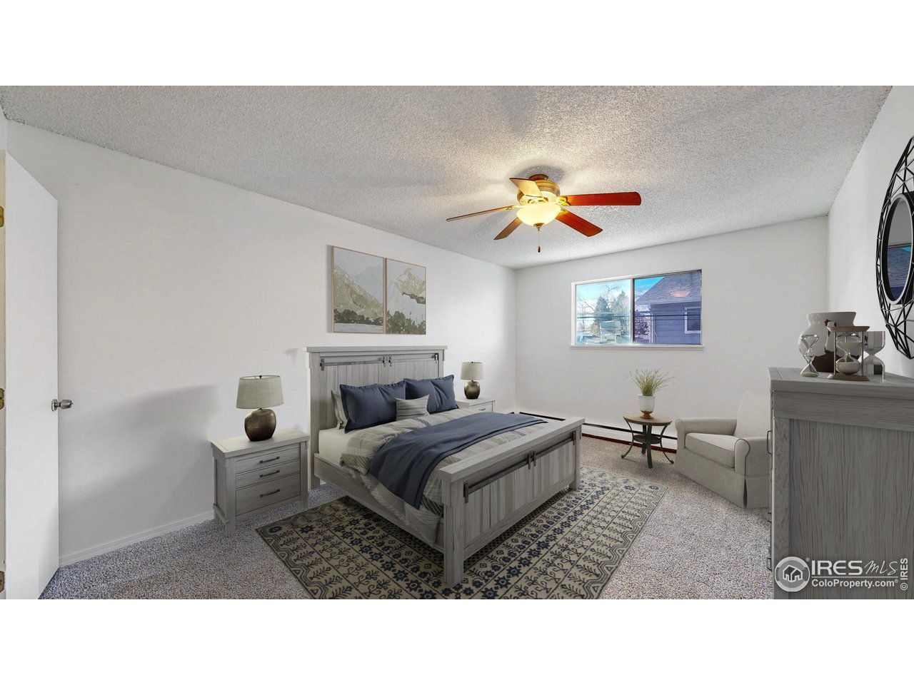 Furnished bedroom with a gray wood bed, patterned rug, and ceiling fan.