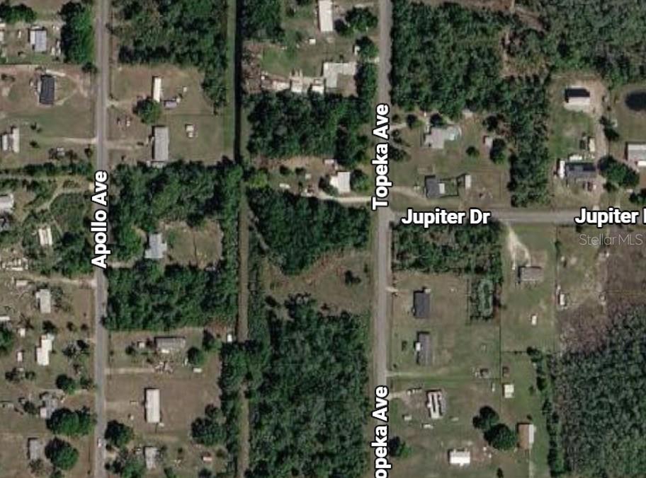 Aerial view of Topeka Avenue with wooded parcels, scattered homes, and nearby streets.