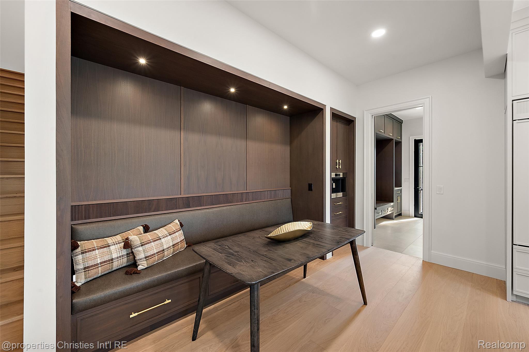 Dining nook with a built-in dark wood banquette, plaid cushions, and a matching table.