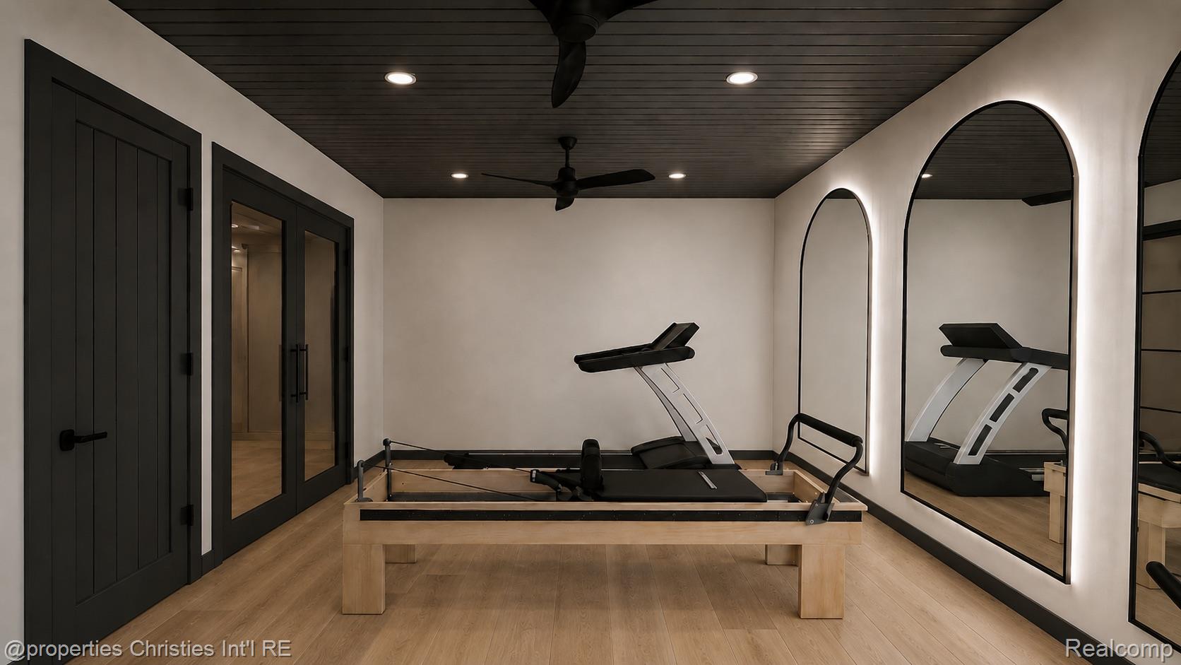 Home gym with a treadmill, Pilates reformer, and arched wall mirrors.