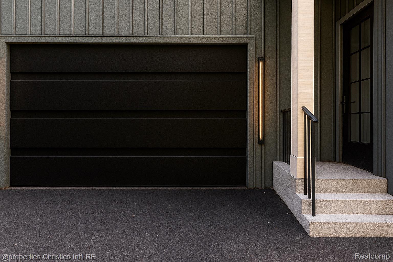 Modern home exterior with a wide dark garage door and raised stone entry steps.