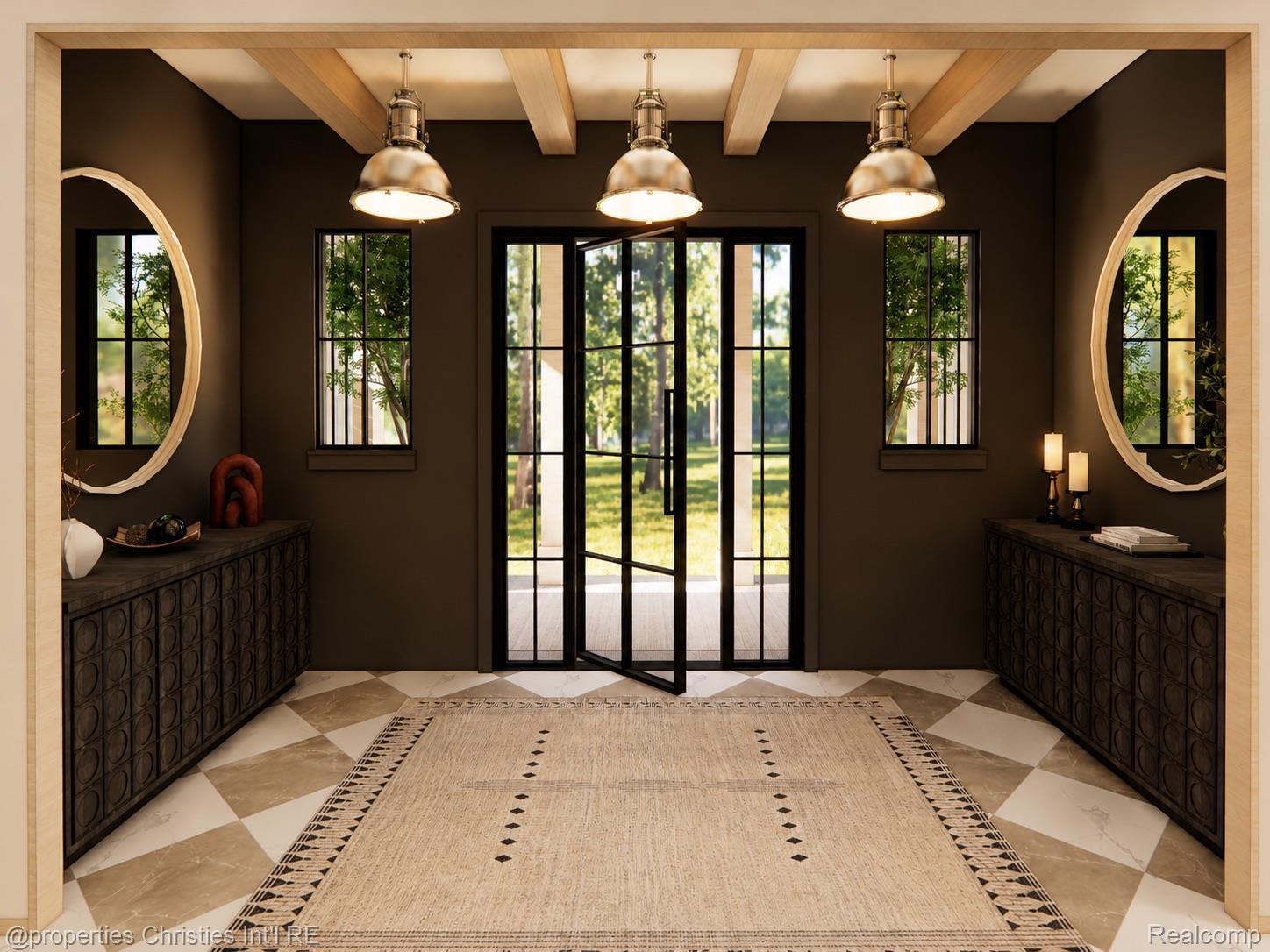 Entry foyer with dark cabinetry, oval mirrors, pendant lights, and a glass door to the yard.