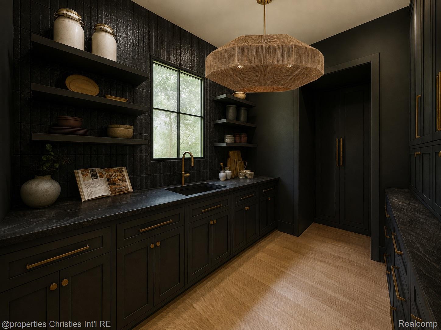 Dark pantry with black cabinetry, marble counters, open shelves, and a sink beneath a tall window.