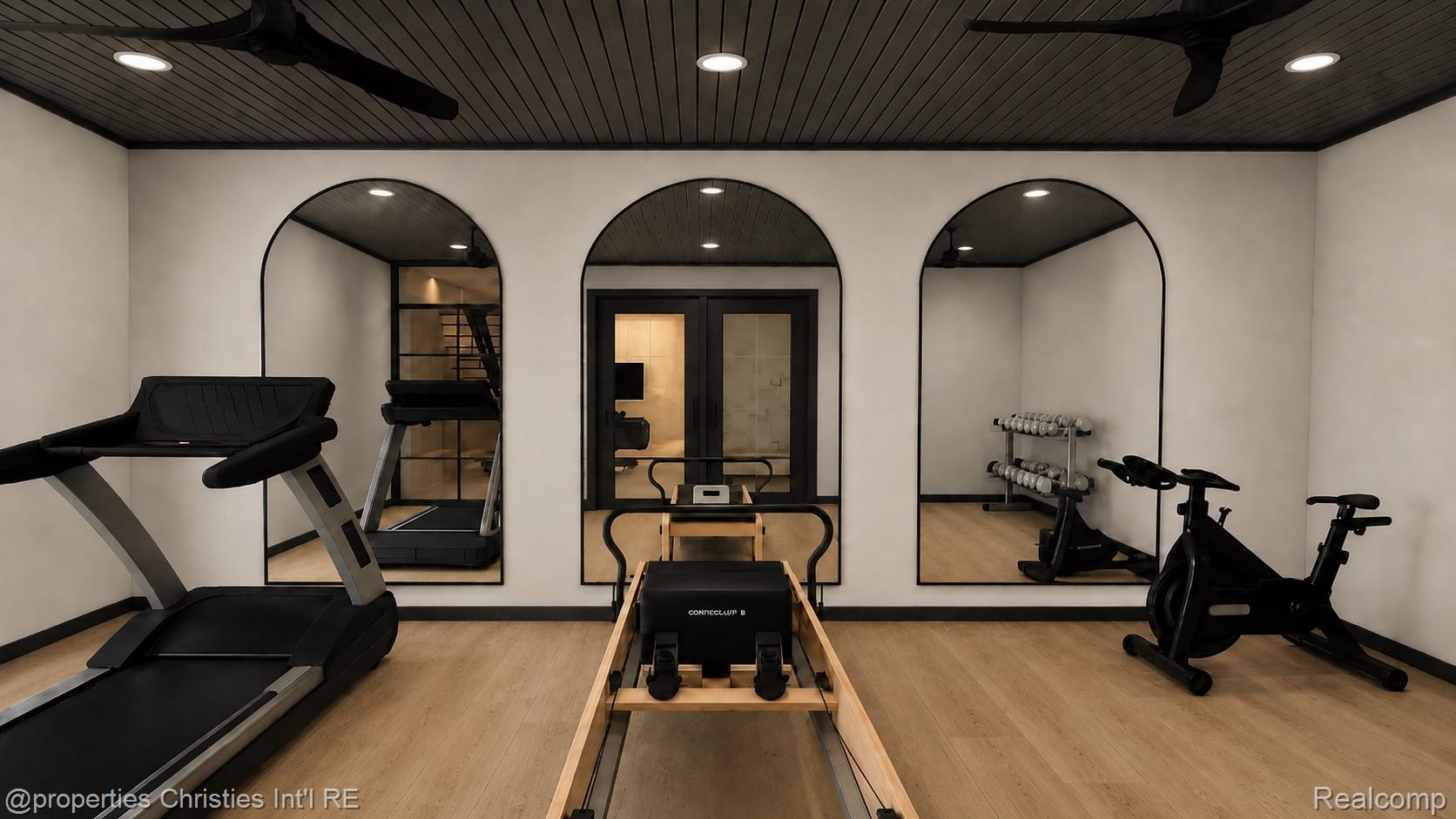 Home gym with arched mirrors, a treadmill, Pilates reformer, stationary bikes, and dumbbells.