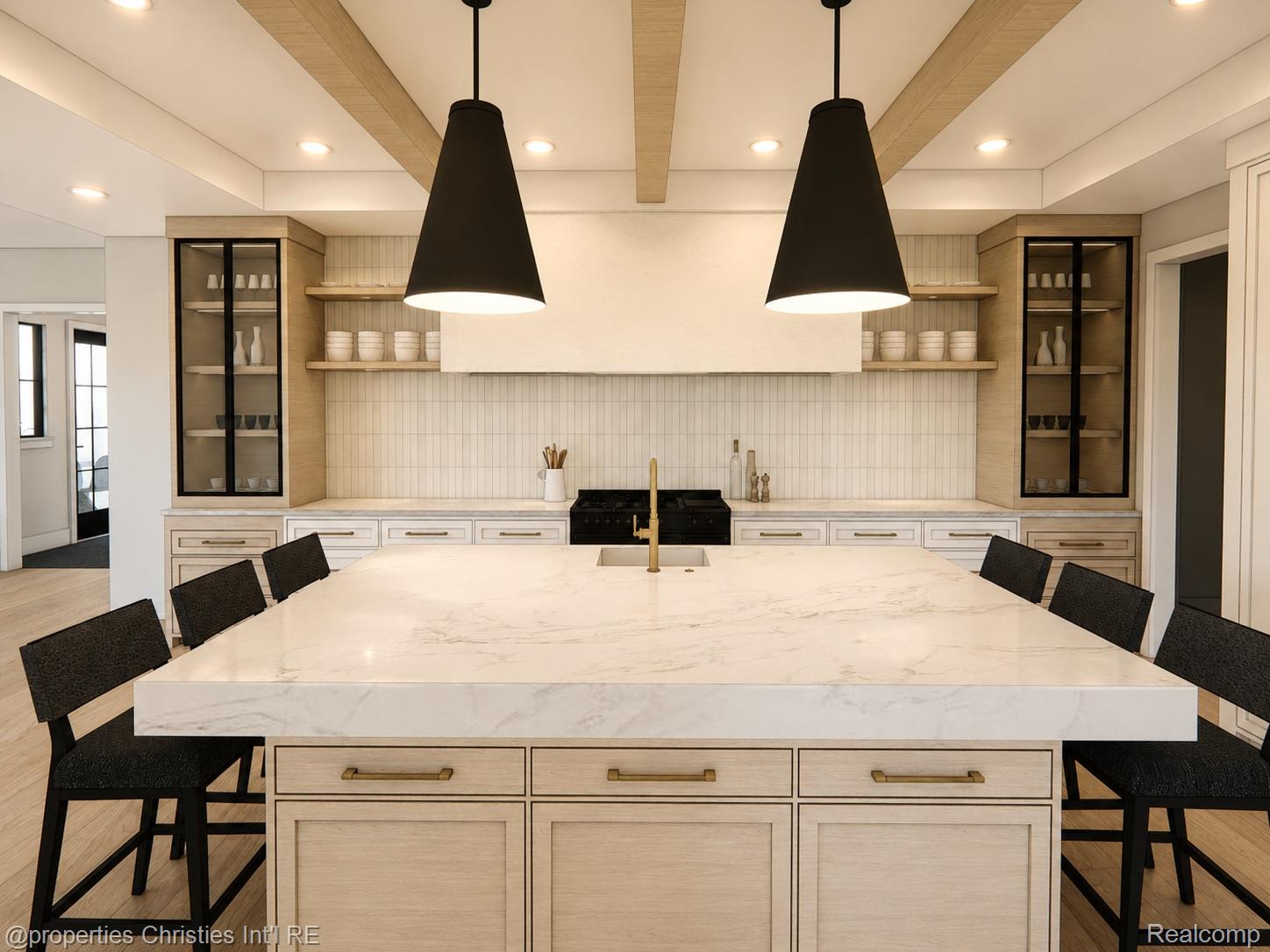 Kitchen with a large marble island, pale wood cabinetry, and oversized black pendant lights.