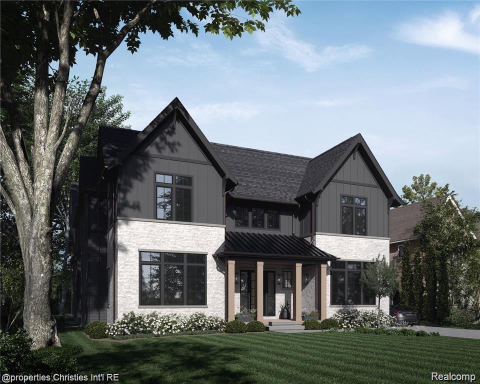 Two-story modern home with dark gables, light stone walls, and a covered front entry.