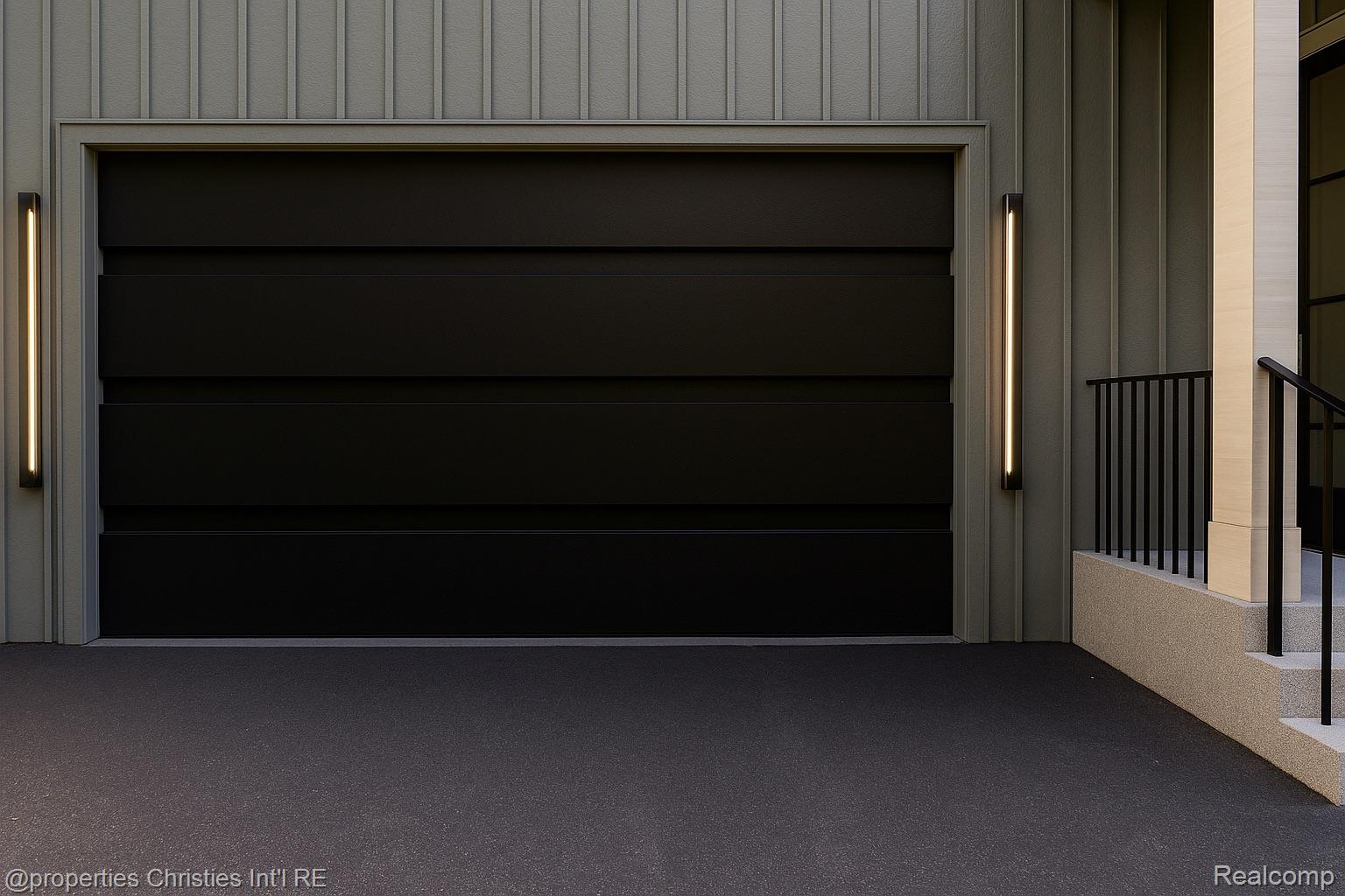 Modern charcoal garage door with gray vertical siding, slim lights, and a black-railed entry.