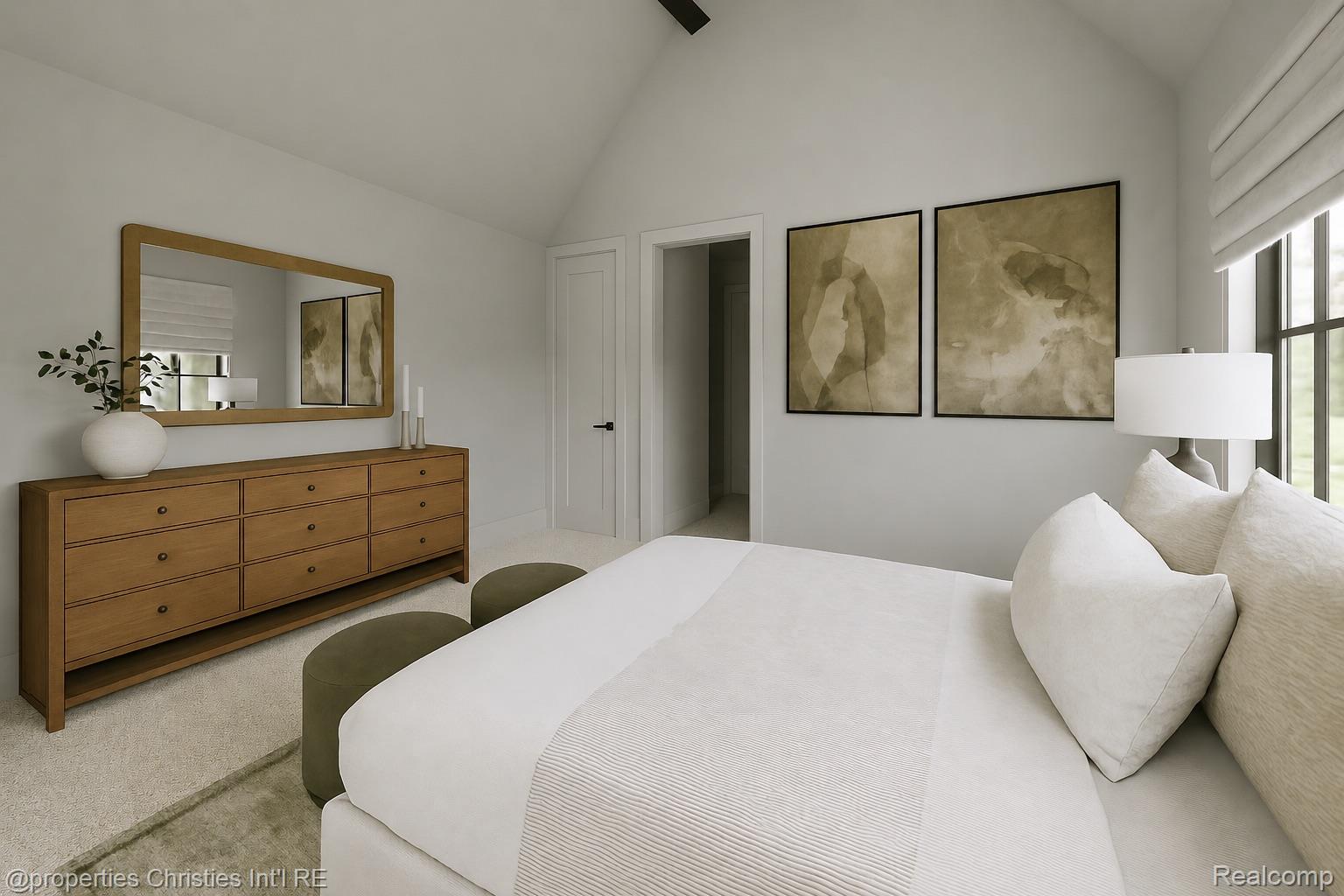 Bedroom with a white bed, wooden dresser and mirror, abstract art, and a large window.