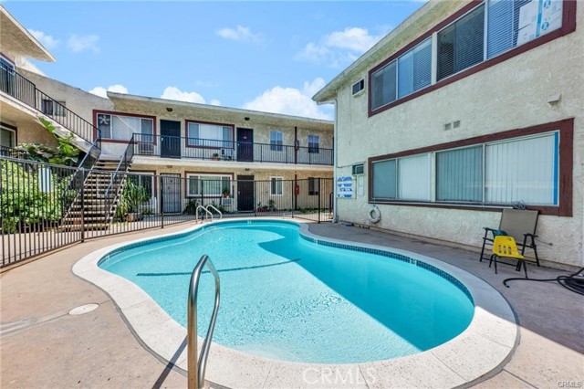 Apartment courtyard pool surrounded by two-story buildings and balconies.
