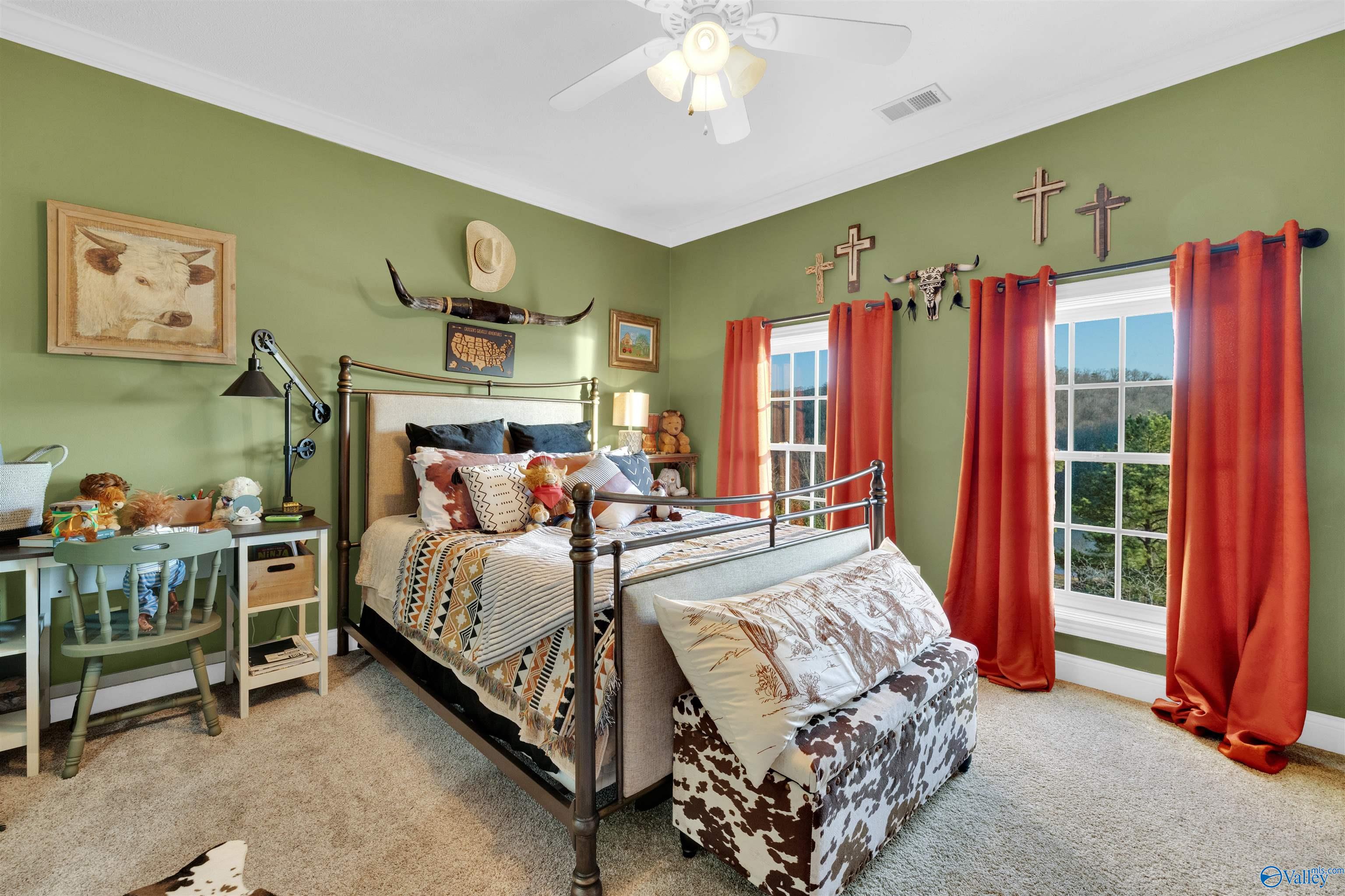 Bedroom with olive-green walls, red curtains, a metal bed, and a cow-print bench.