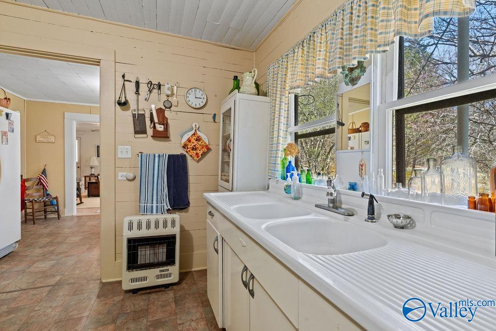 Kitchen with a long double-basin sink beneath large windows and a washer under the counter.
