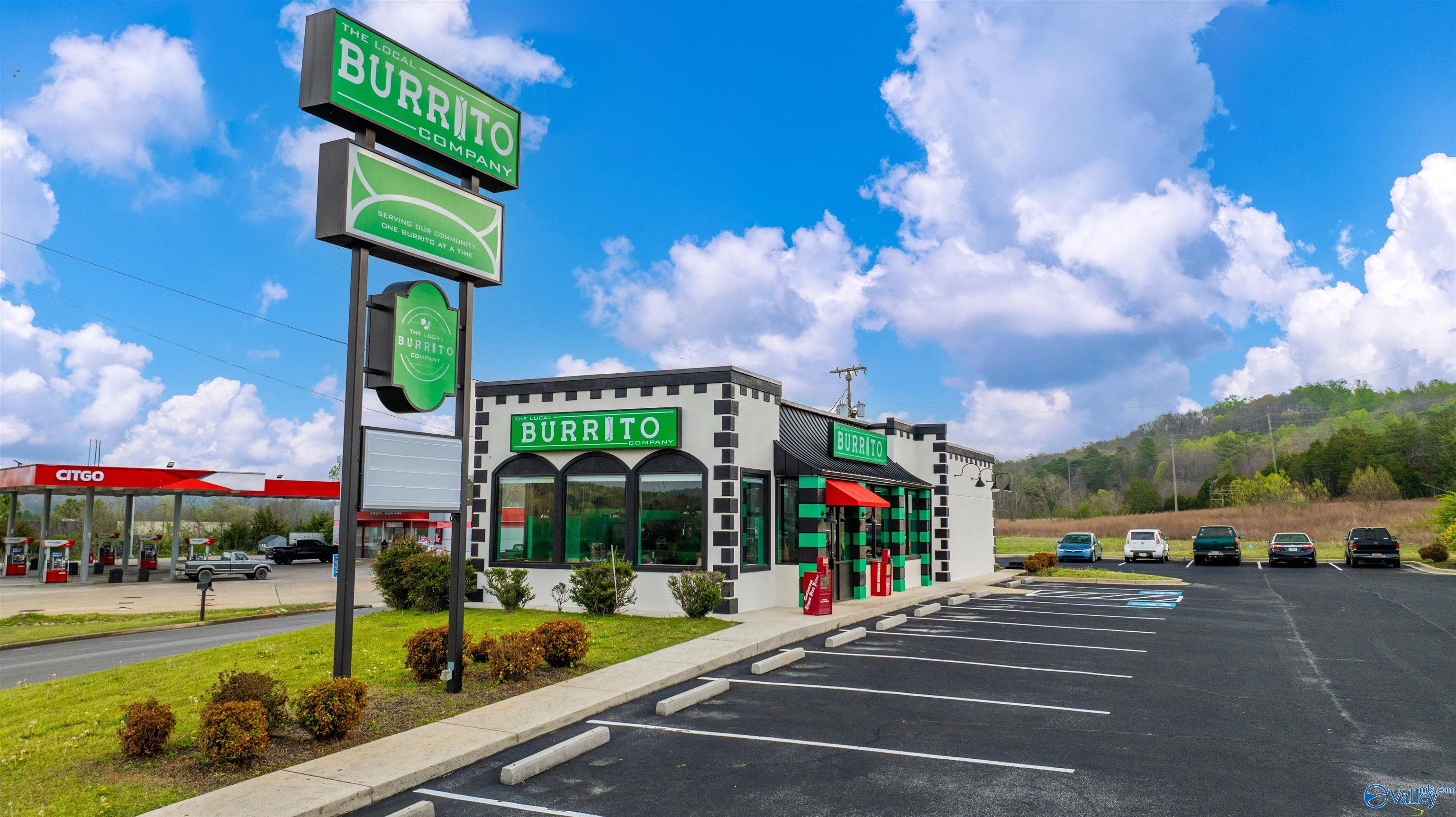 The Local Burrito Company restaurant exterior with its tall roadside sign and adjacent parking lot.