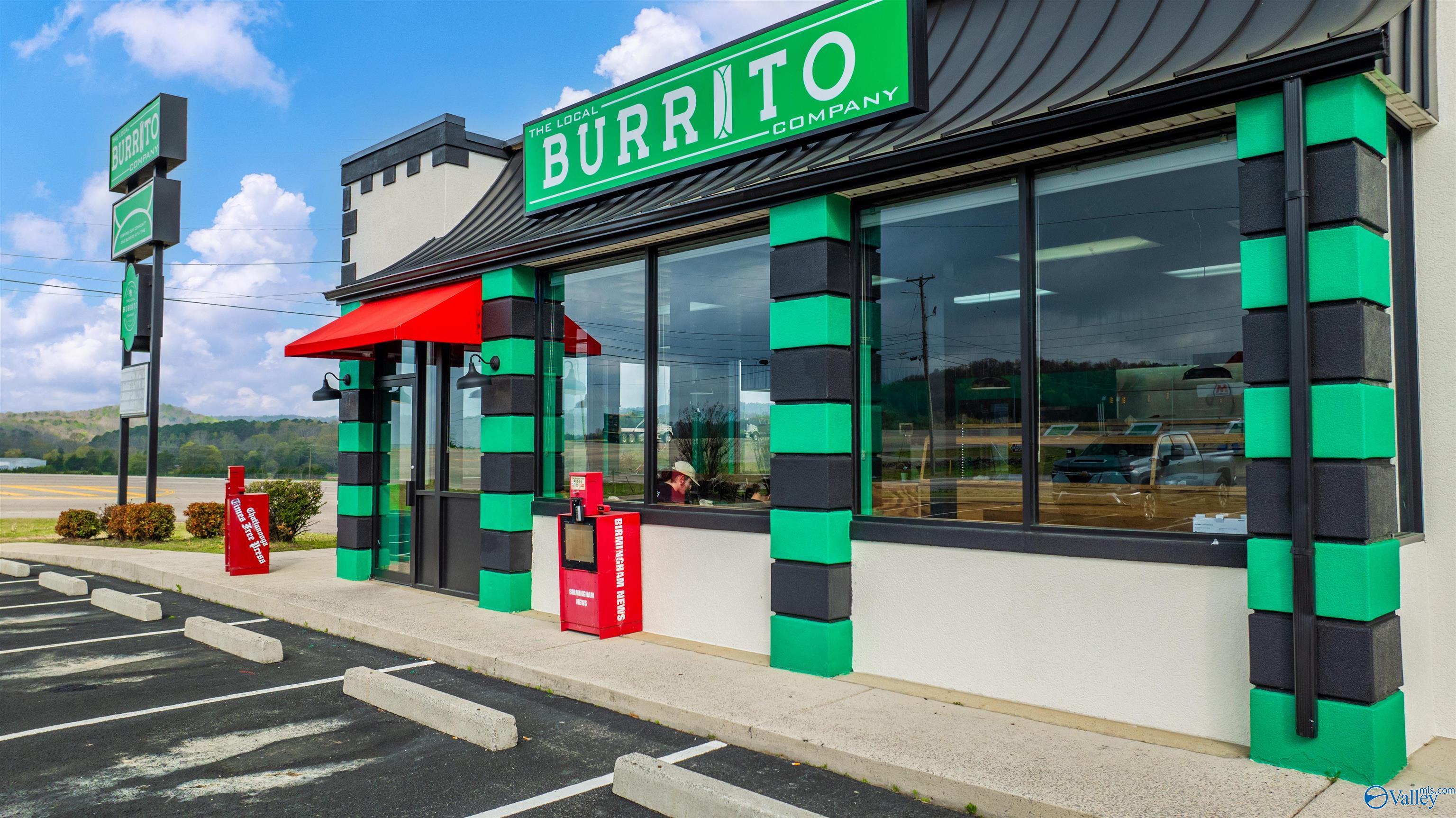 Commercial storefront with green-and-black trim, a Burrito Company sign, and a red awning.
