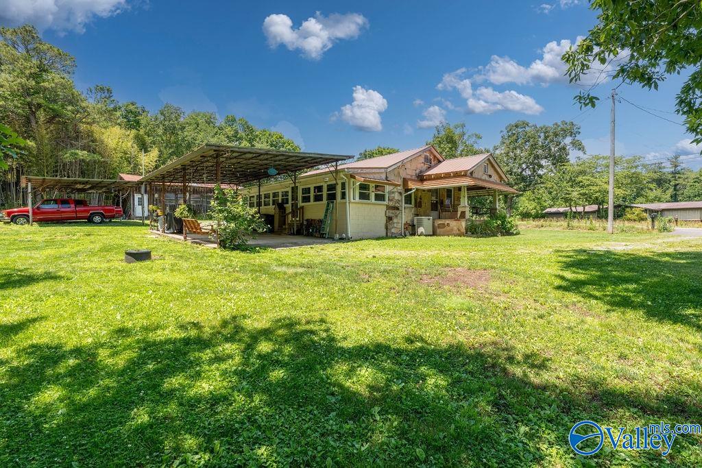 Single-story home with a metal-roofed carport and broad grassy yard.