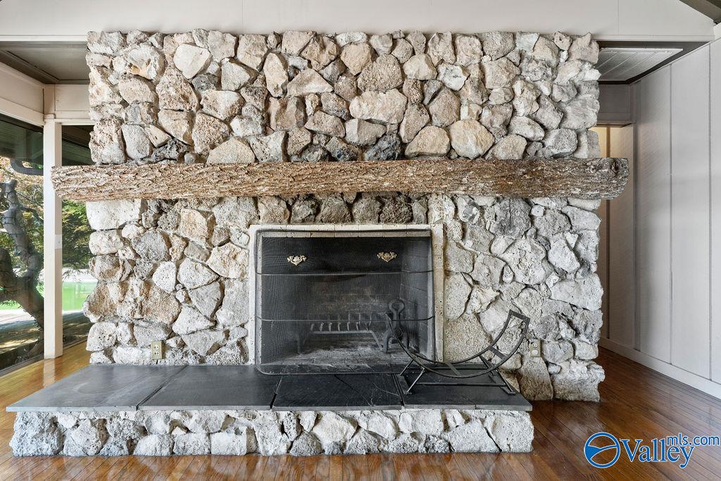 Stone fireplace with a rough-hewn timber mantel and wide black hearth.