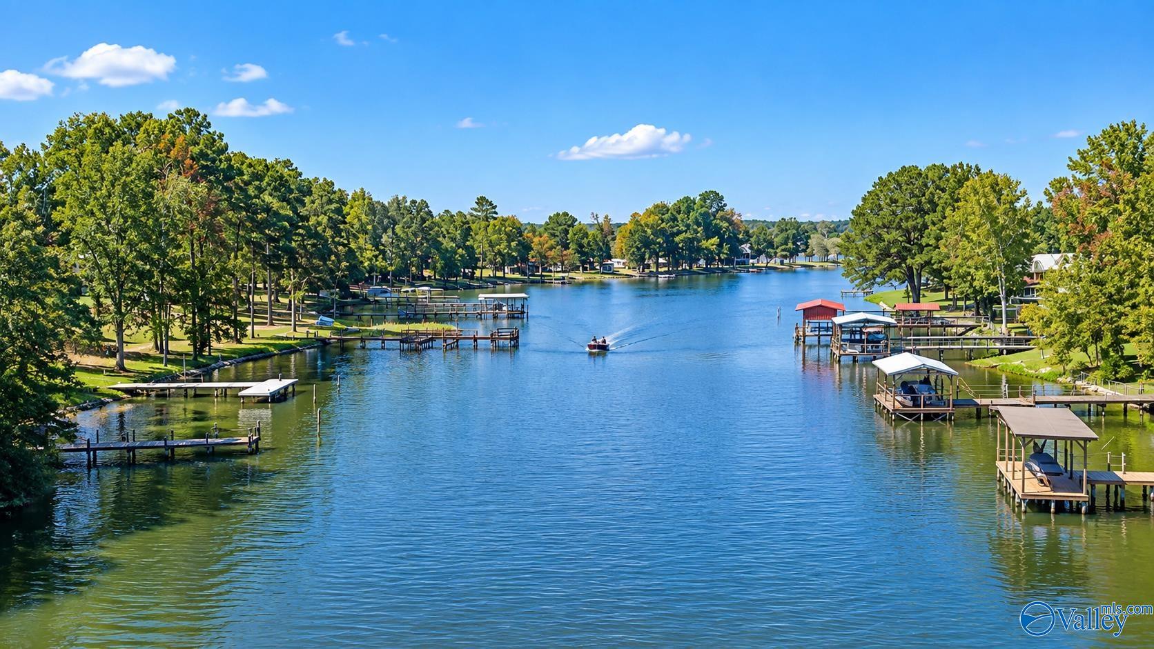 Tree-lined lake with docks and boathouses along both shores.