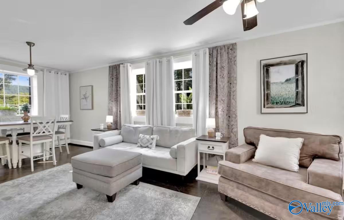 Furnished living room with two sofas, an ottoman, and an adjoining dining area.