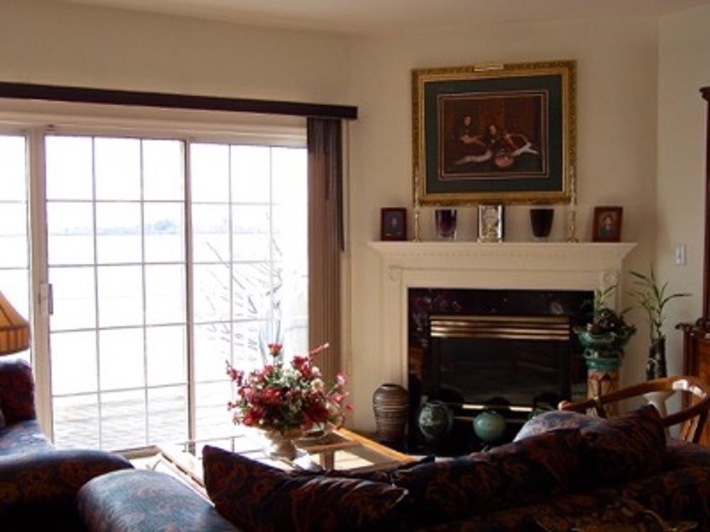 Living room with a white fireplace and sliding glass doors.