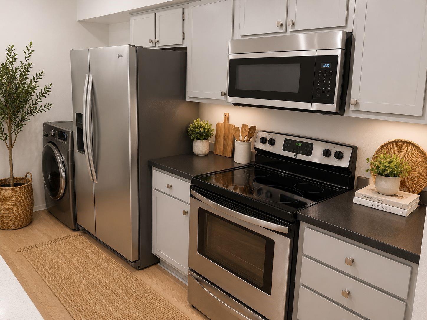 Kitchen with stainless steel appliances, a black glass-top range, and a front-loading washer.