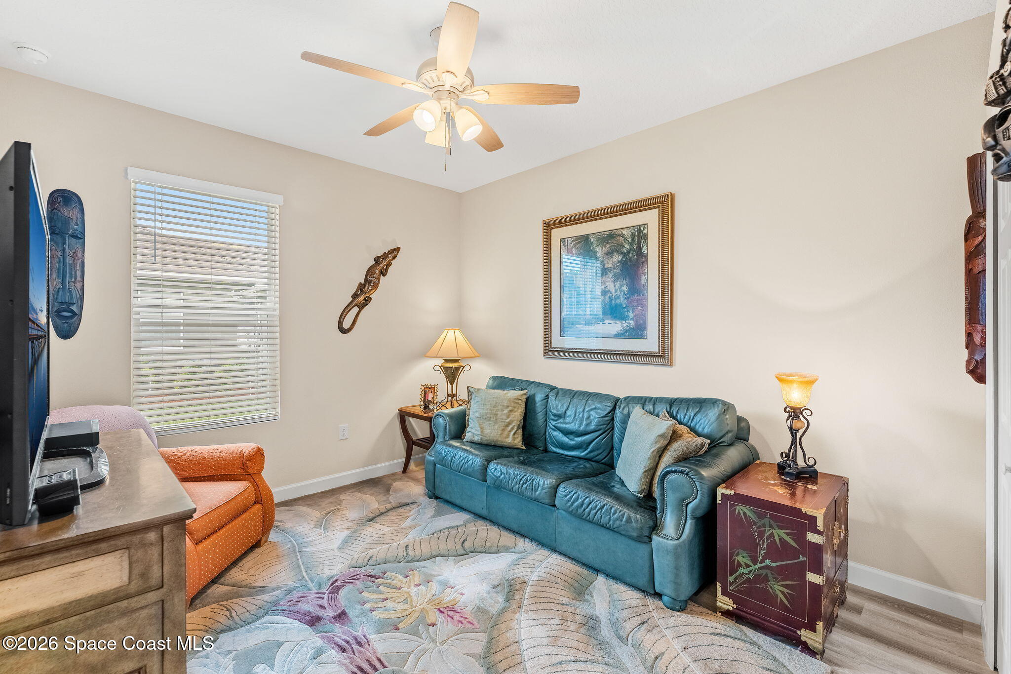 Living room with a blue leather sofa, orange recliner, and large patterned rug.