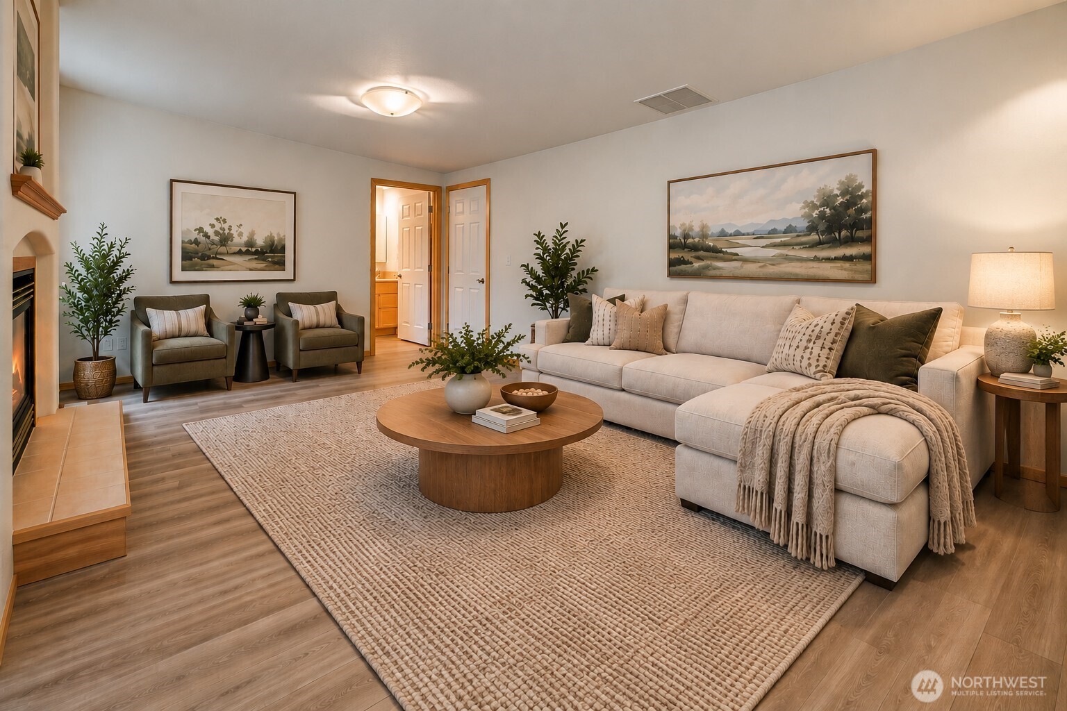 Furnished living room with a cream sectional, two armchairs, and a fireplace.