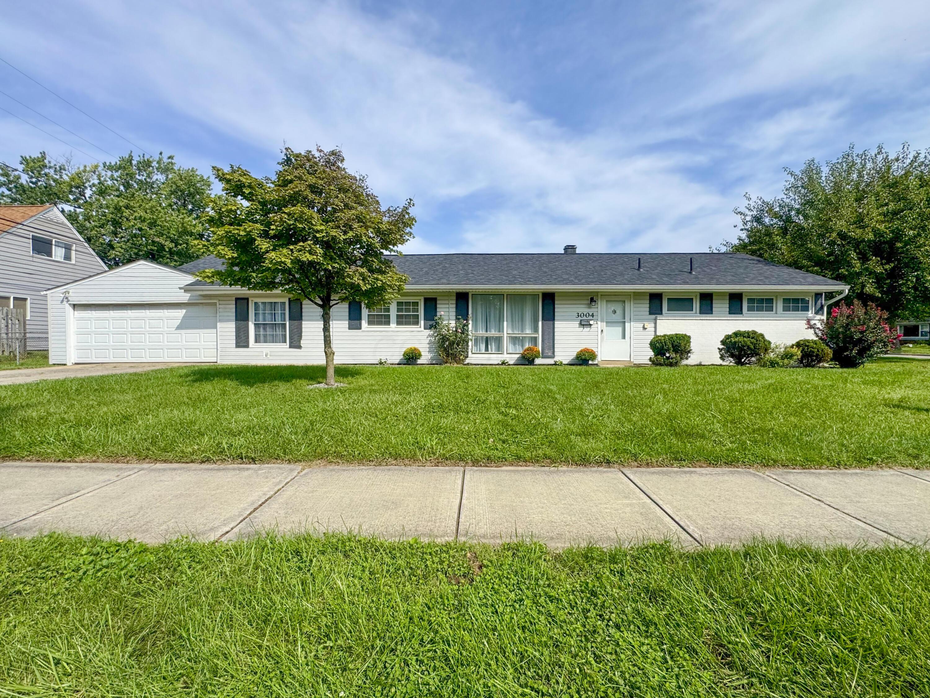 Single-story white house with an attached garage, broad lawn, and number 3004 beside the front door.
