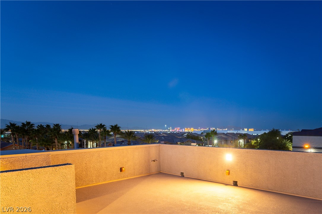 Rooftop terrace overlooking the illuminated Las Vegas skyline at night.