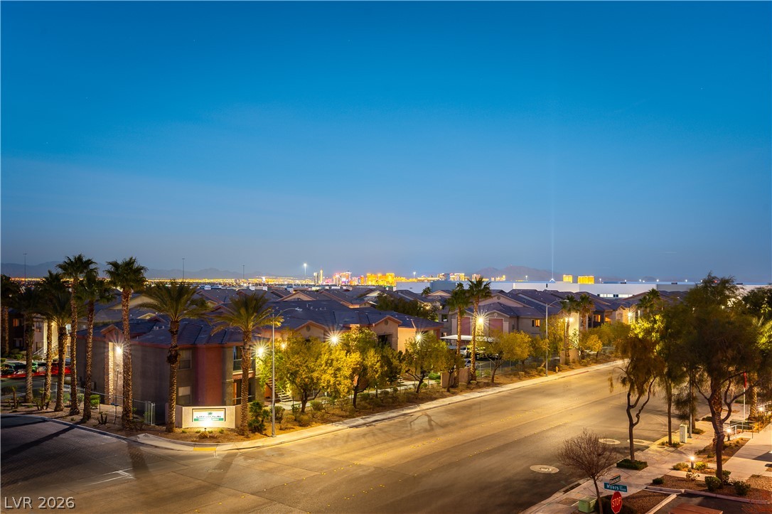 Residential neighborhood at night with palm trees and the Las Vegas skyline.