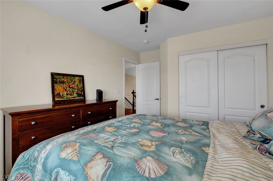 Bedroom with a blue seashell-patterned comforter and dark wood dresser.