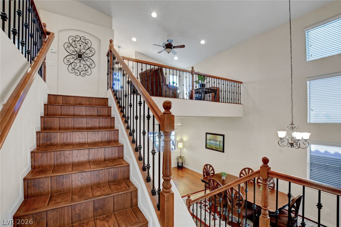 Two-story foyer with a broad wood staircase, iron balusters, and dining area below.