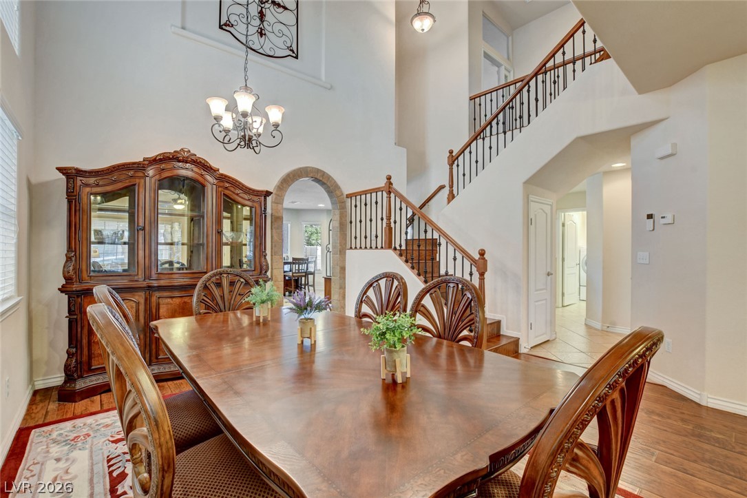 Dining room with a large wooden table, ornate china cabinet, and sweeping staircase.