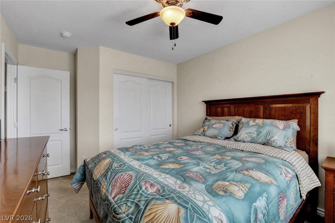 Furnished bedroom with turquoise seashell bedding and a dark wood headboard.