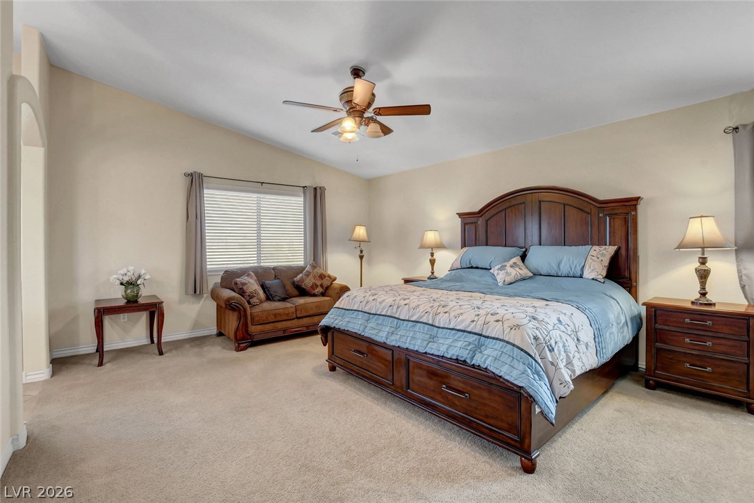 Furnished bedroom with a dark wood bed, blue bedding, and a brown loveseat.