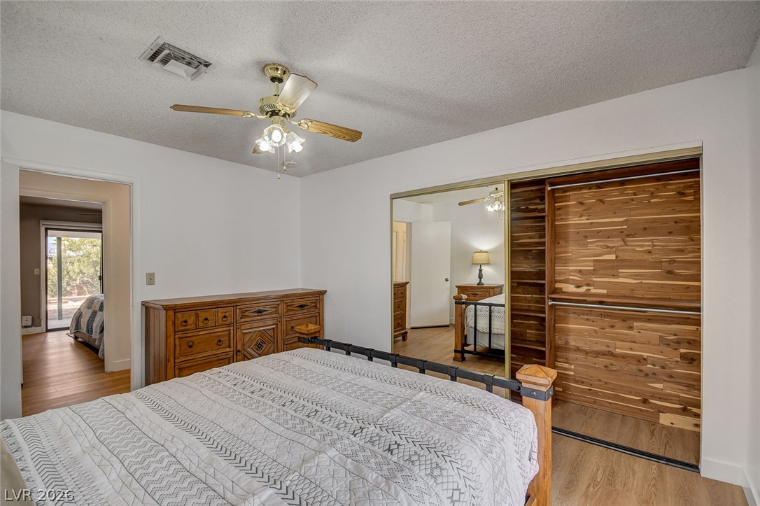 Furnished bedroom with a wooden dresser and mirrored sliding closet doors.