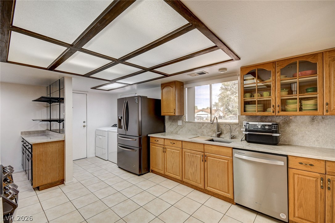 Kitchen with wood cabinets, stainless steel appliances, and dark exposed ceiling beams.