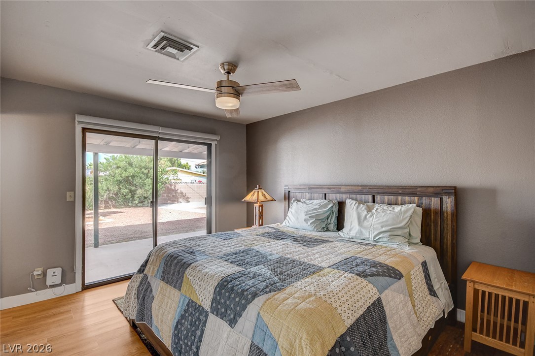 Bedroom with a patchwork-covered bed and sliding glass doors to the backyard.
