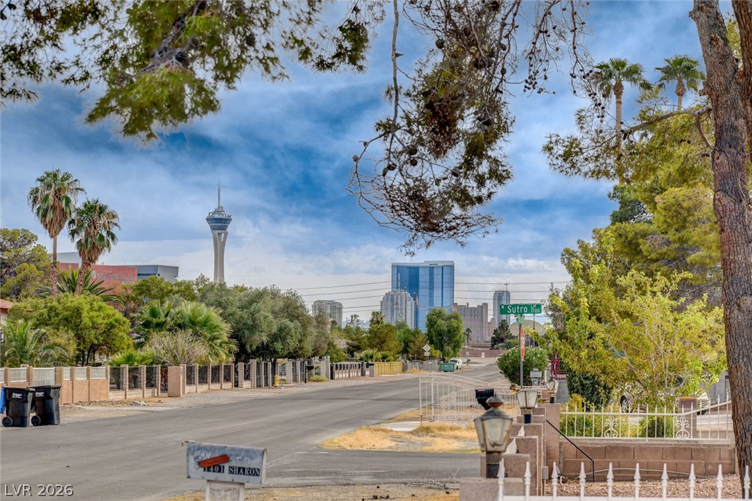 Street outside 1401 Sharon Road, framed by trees with the Las Vegas skyline beyond.
