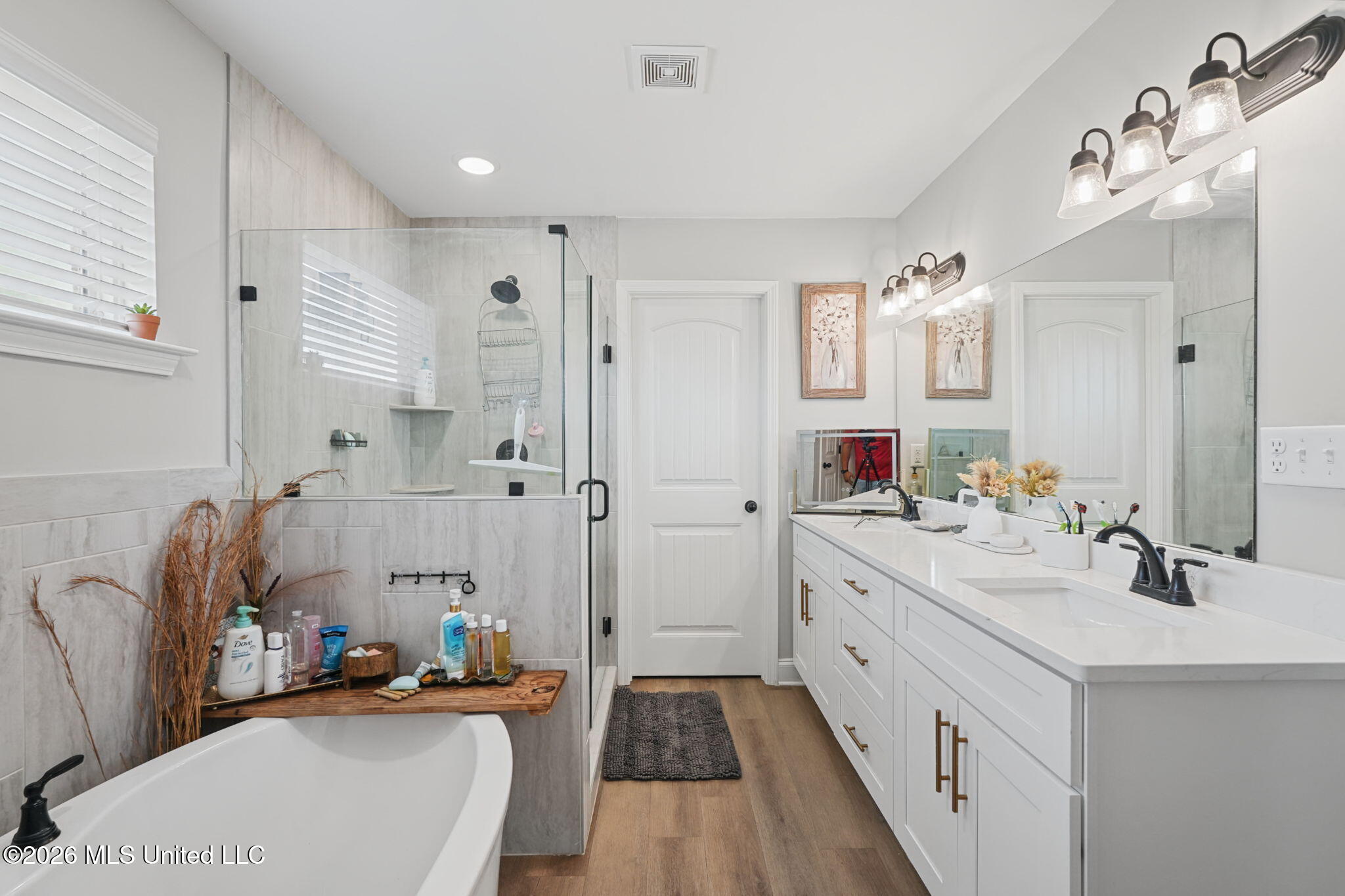Bathroom with a glass shower, freestanding tub, and long double vanity.