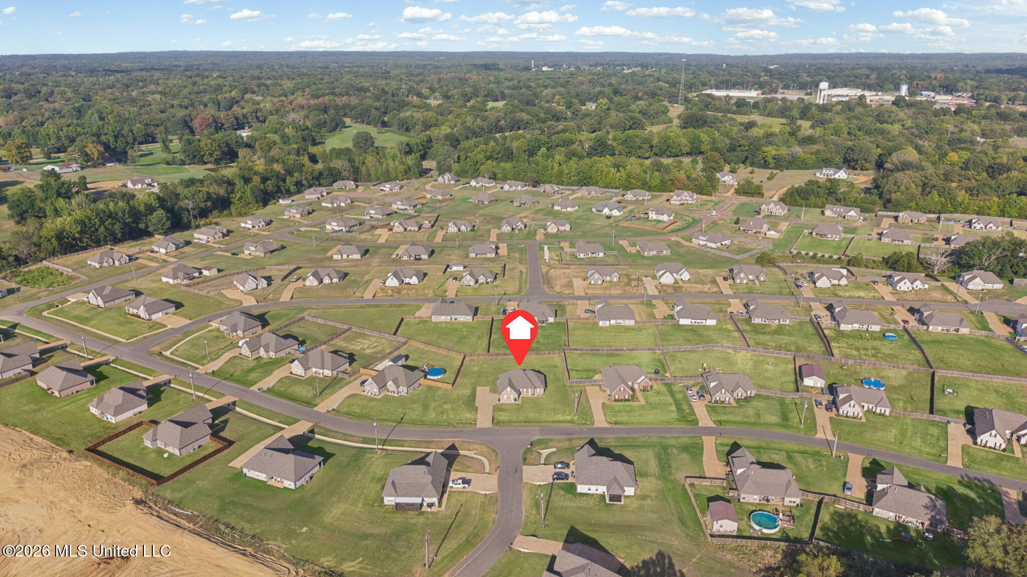 Aerial view of a residential subdivision, with a red map pin marking the property.