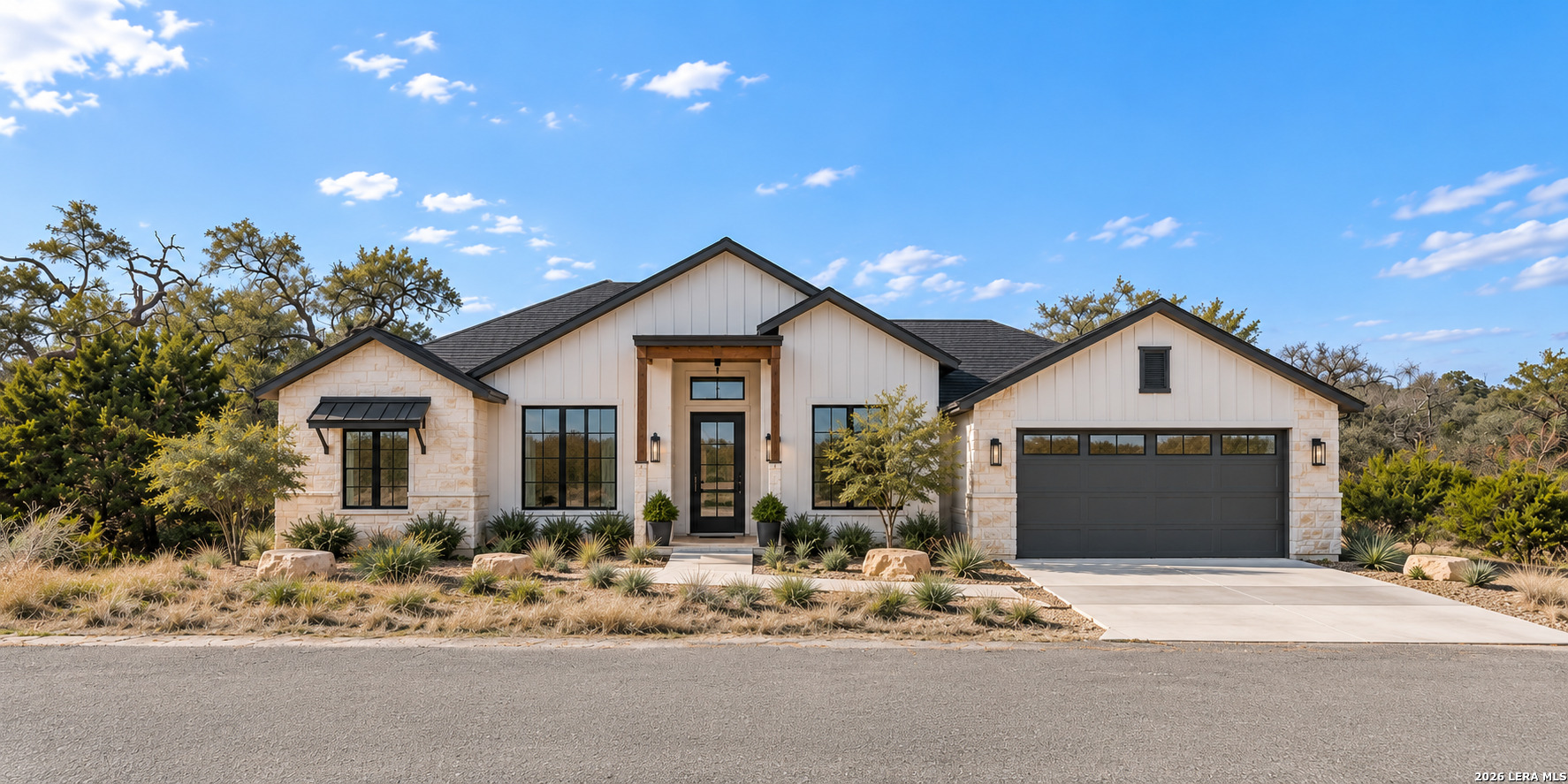 124 Hiram Cook home with light stone and white siding, dark trim, and a two-car garage.