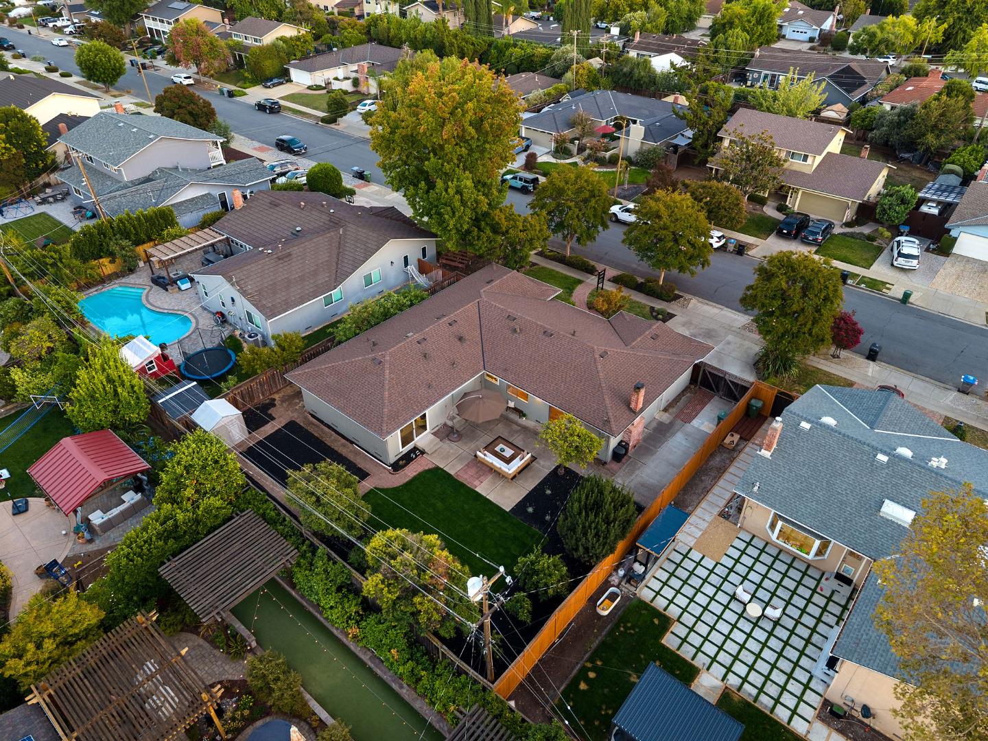 Aerial view of a single-story home with a landscaped lawn and backyard patio.
