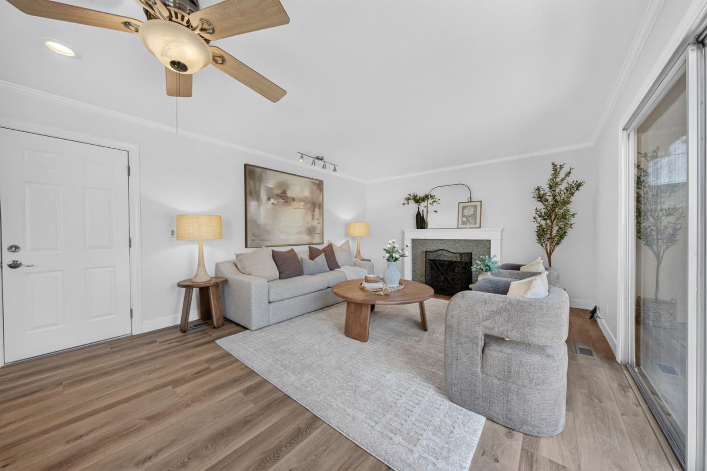 Living room with gray seating, a fireplace, and sliding glass doors.