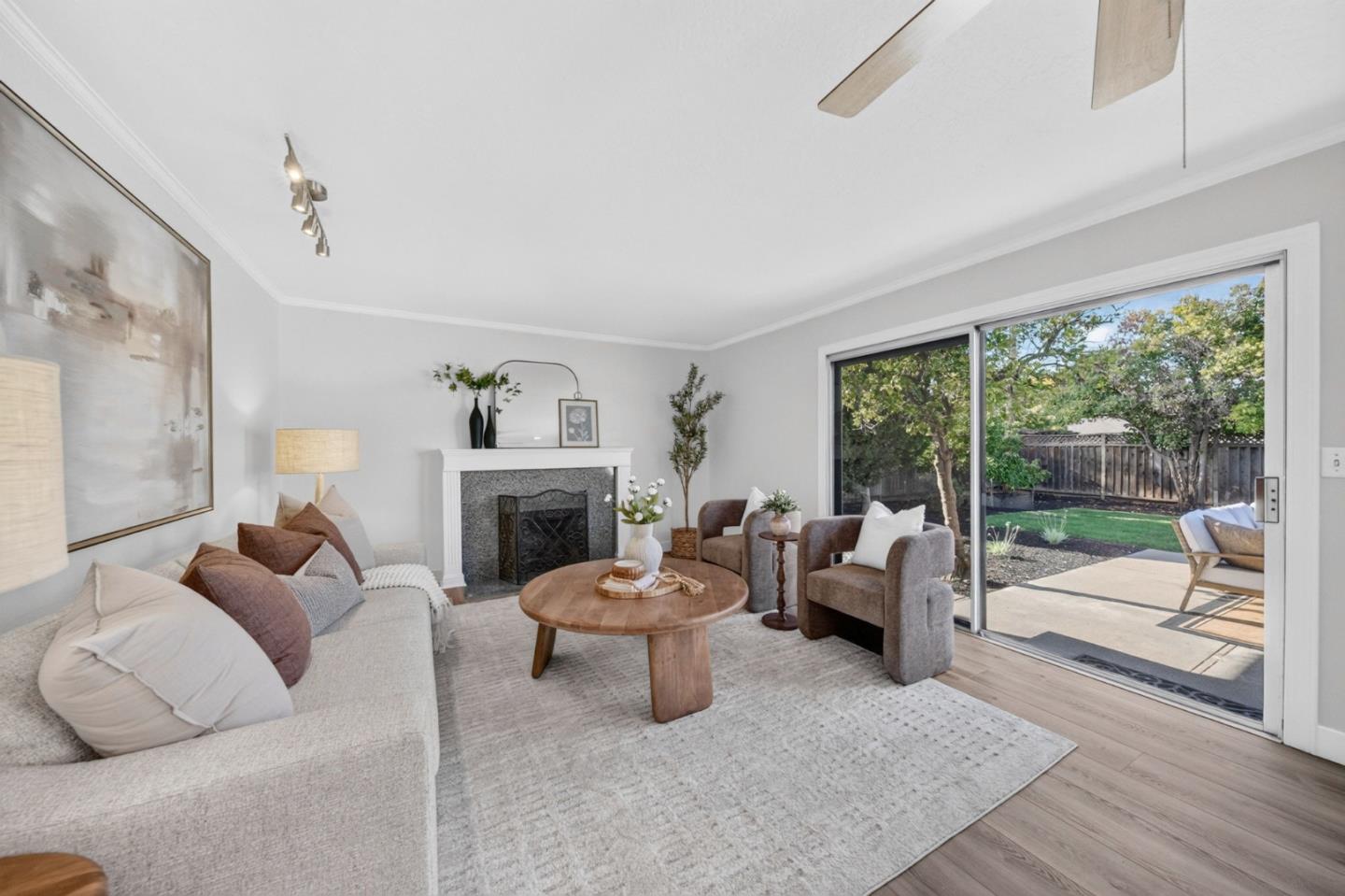 Living room with a fireplace and sliding doors opening onto a backyard patio.